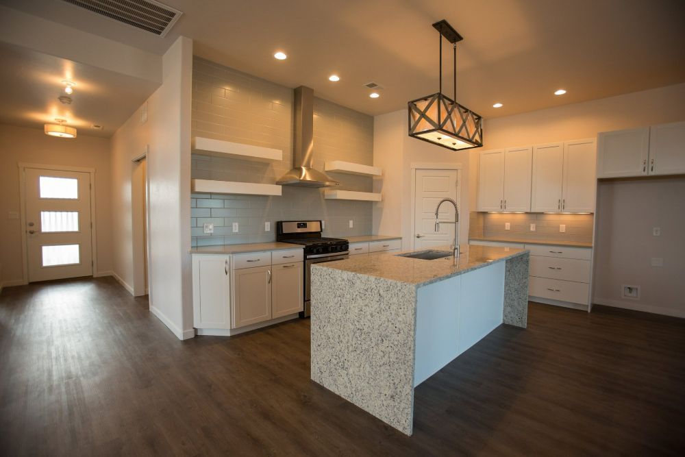 Kitchen remodel in Woodbury, MN featuring custom white cabinetry, large island, quartz countertops, and open-concept layout