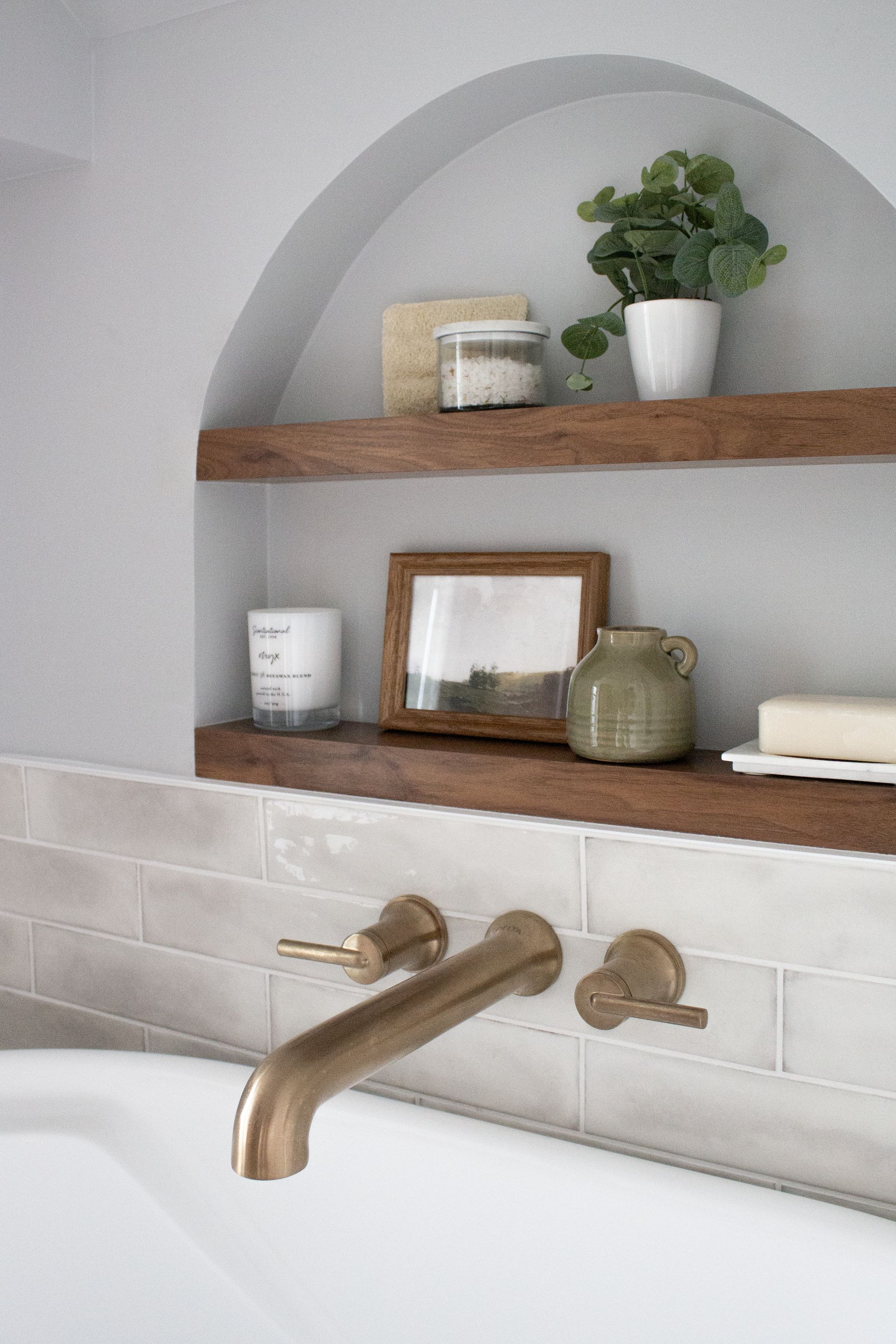 Custom bathroom remodel in St. Paul, MN showcasing an arched wall niche with wood shelving and decorative accents