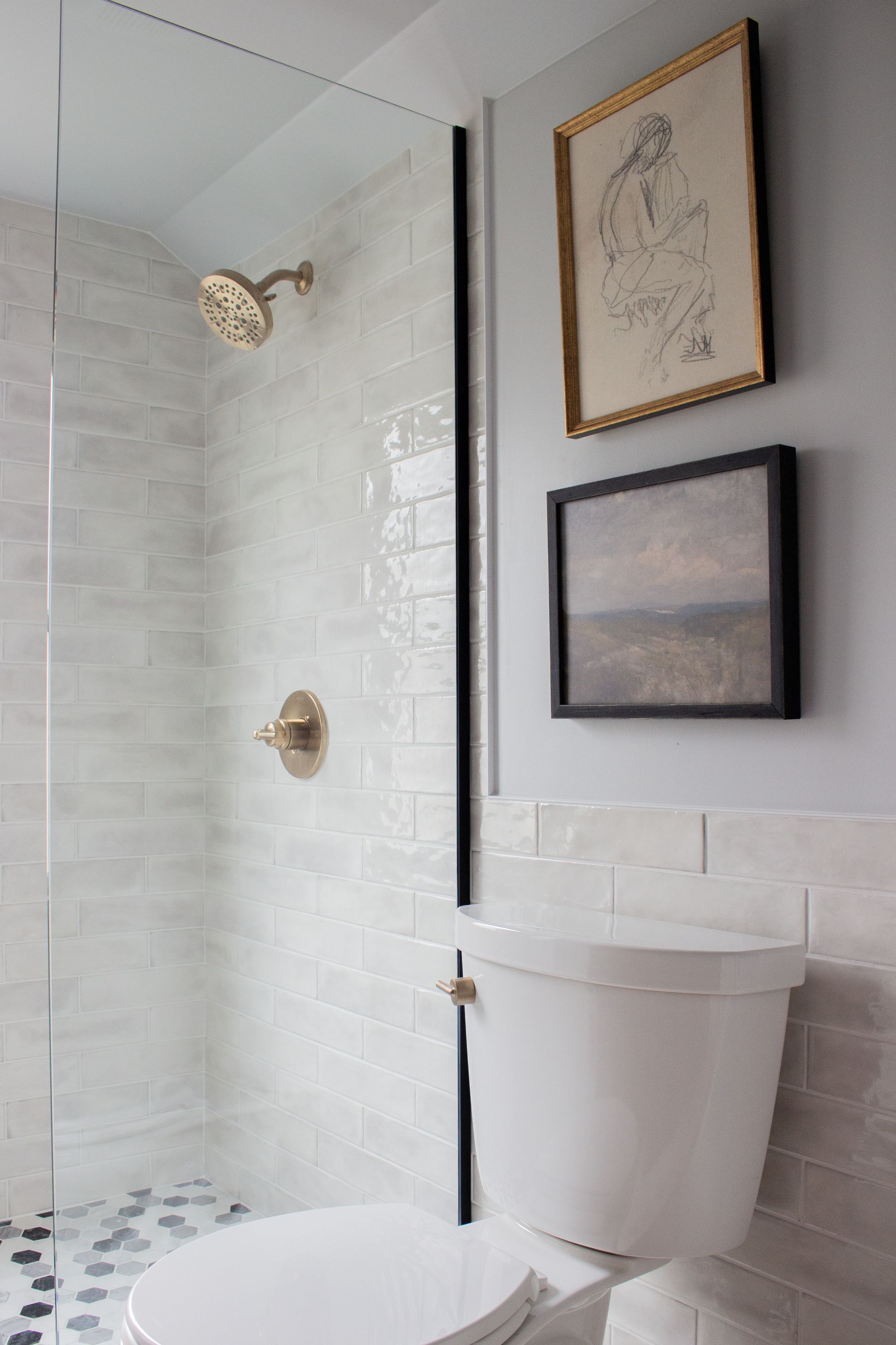Bathroom remodeling project in St. Paul, MN featuring a custom tile shower with brass rainfall showerhead and frameless glass enclosure