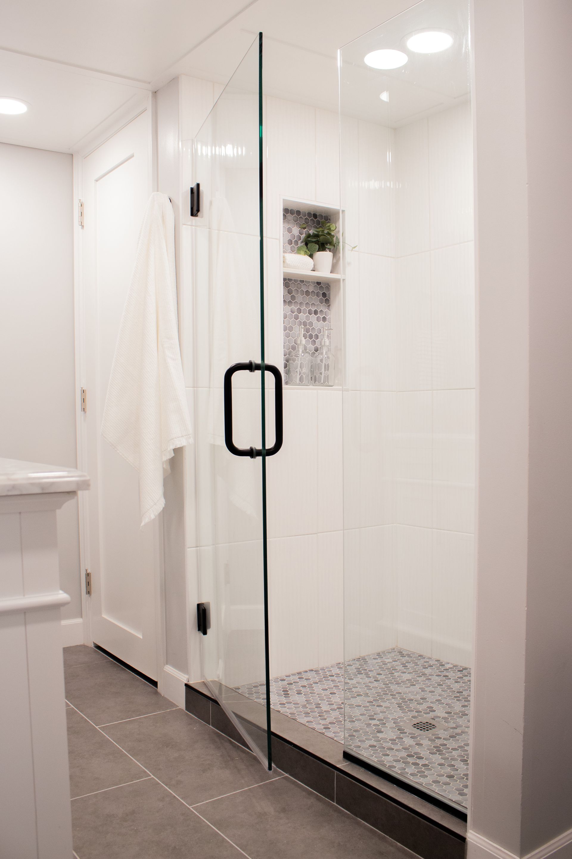 Bathroom renovation in St. Paul, MN with frameless glass shower enclosure and bright modern finishes