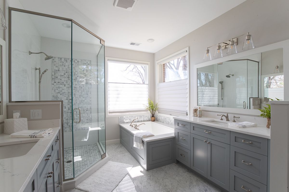 A Bathroom with Two Sinks , a Tub and A Walk in Shower.