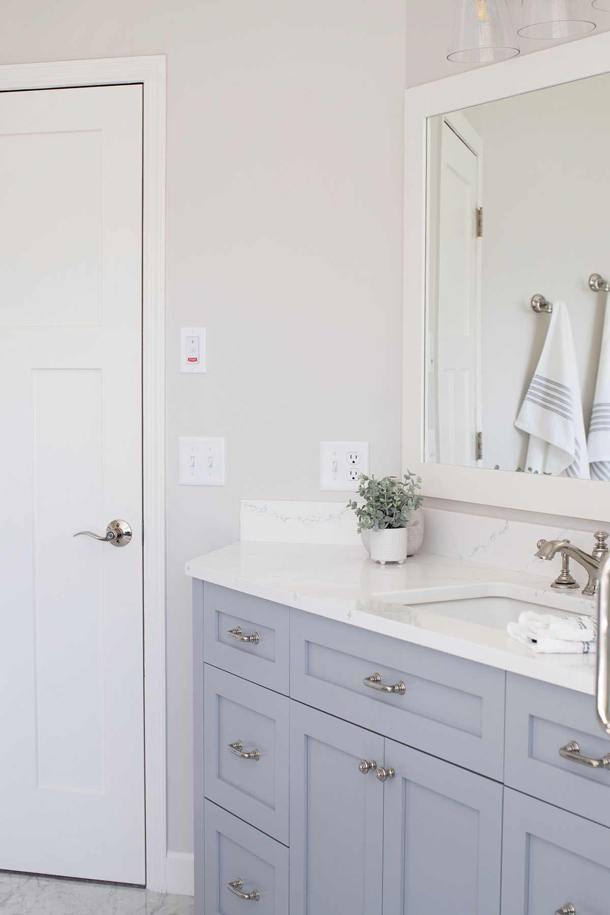 A Bathroom with Blue Cabinets , a Sink , and A Mirror.