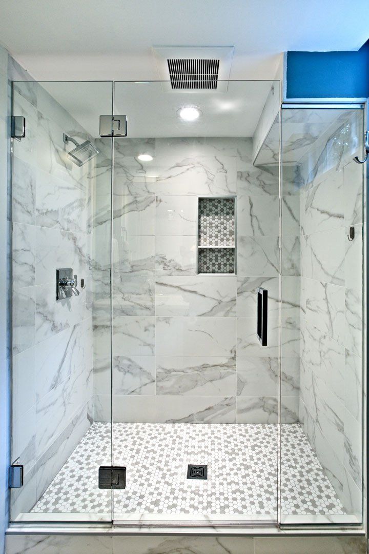 Luxury bathroom remodeling project in St. Paul with walk-in glass shower, marble-look tile walls, and custom niche