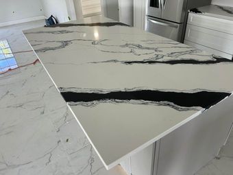 White marble-look kitchen island with bold black veining in a modern kitchen.