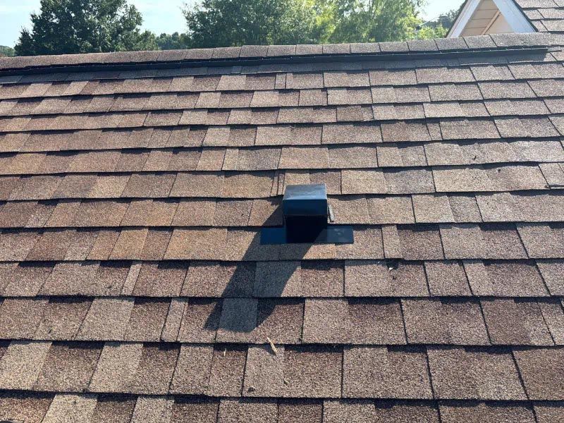 A roof with shingles and a small hole in the middle
