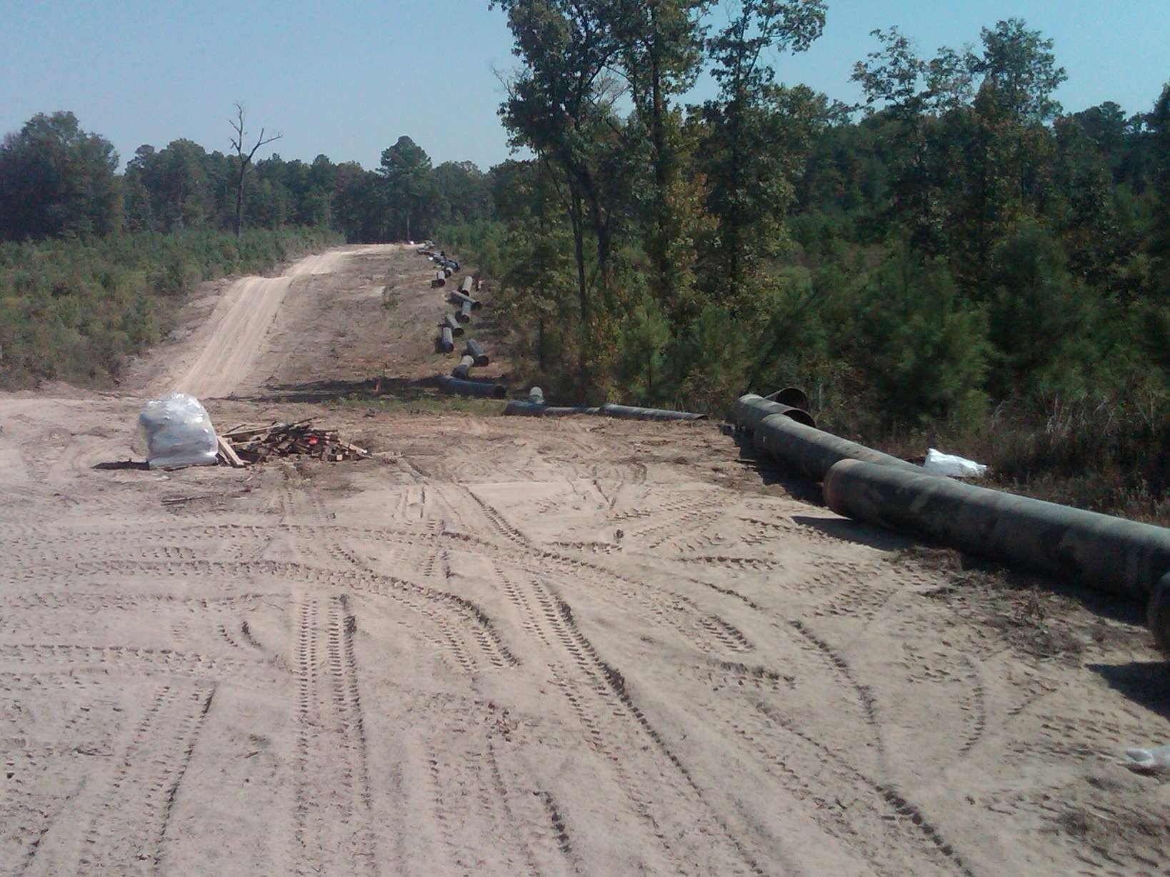 A dirt road with pipes on the side of it