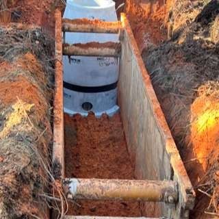A septic tank is being installed in a hole in the ground.