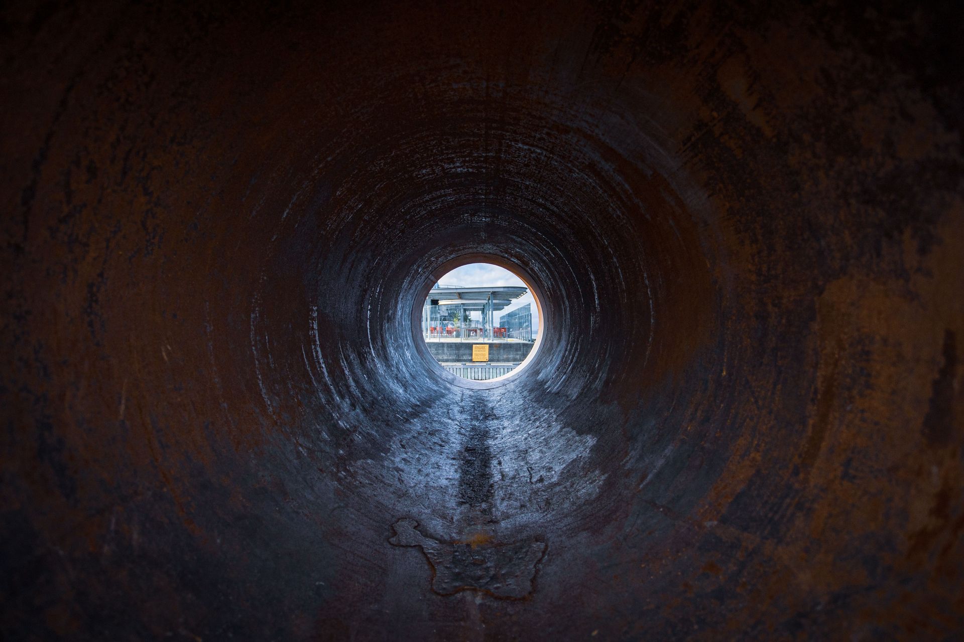 A large pipe is being installed on the side of a road.