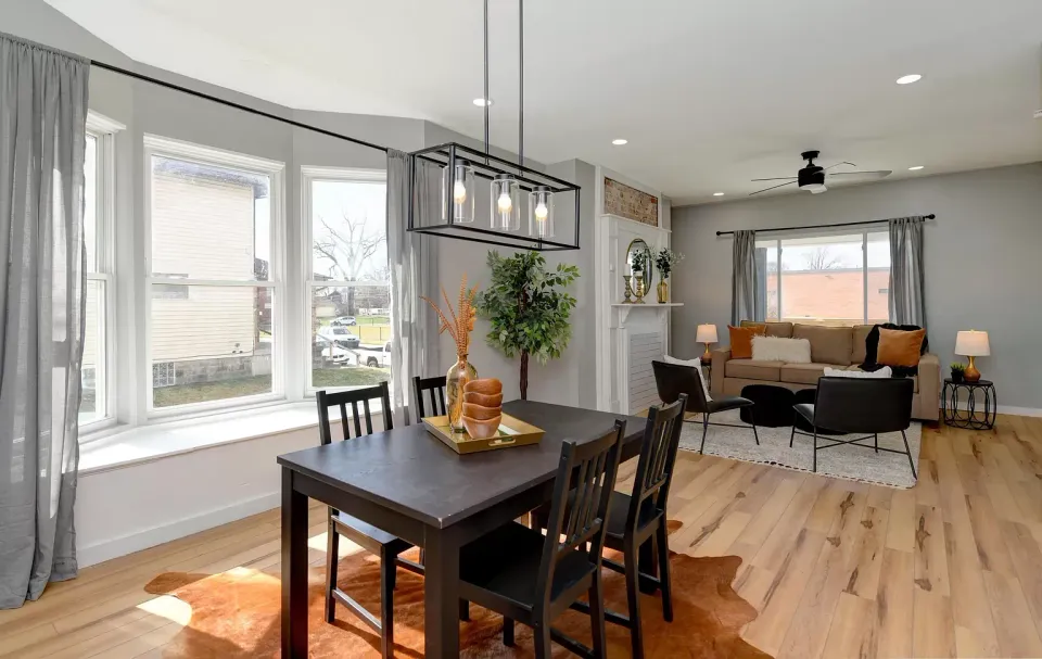 A dining room table and chairs in a living room.