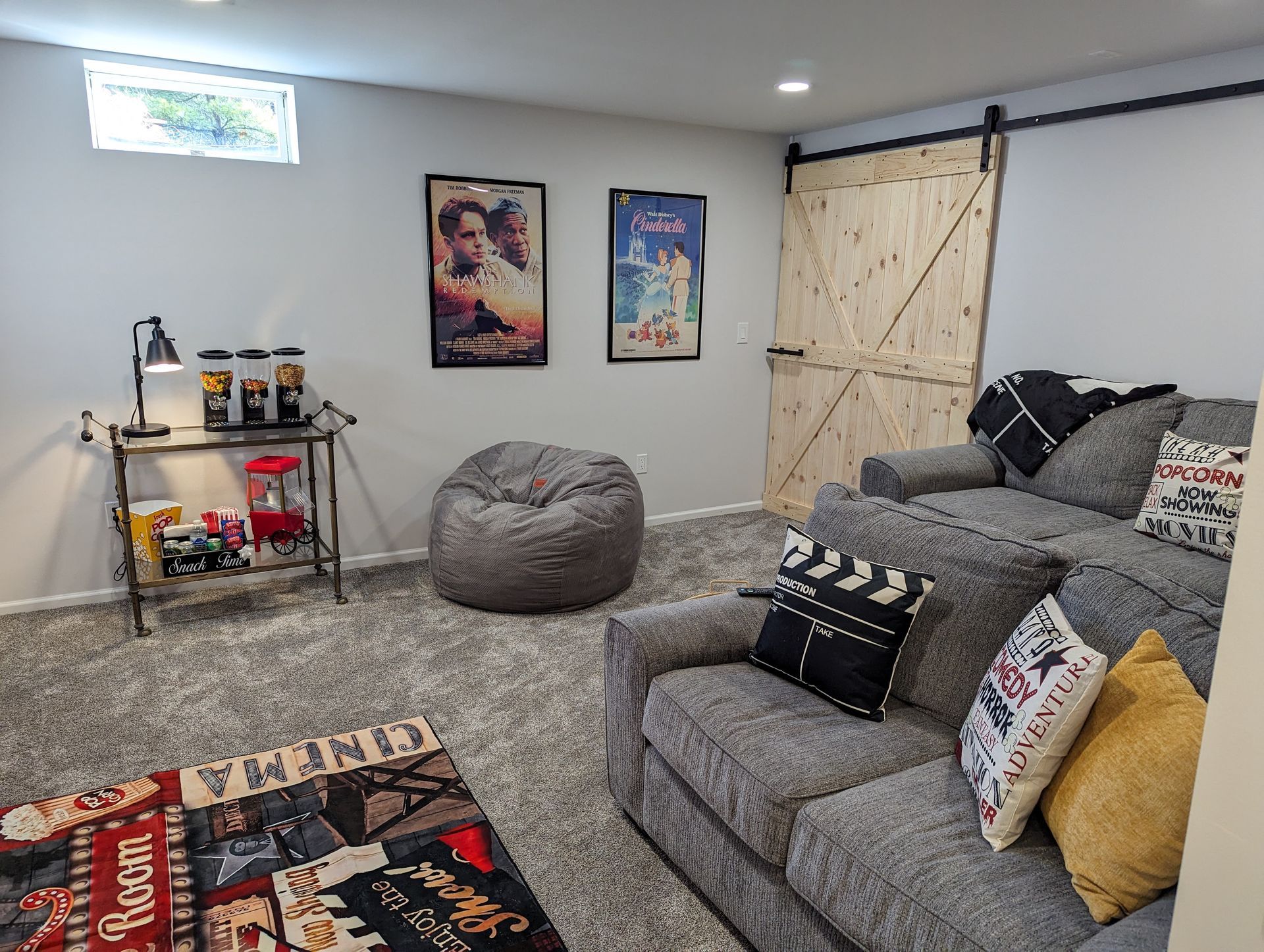 A living room with a couch , chairs , and a sliding barn door.