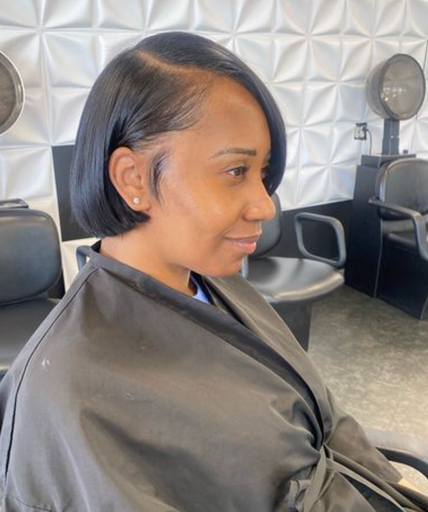 A woman is getting her hair washed in a sink at a salon.