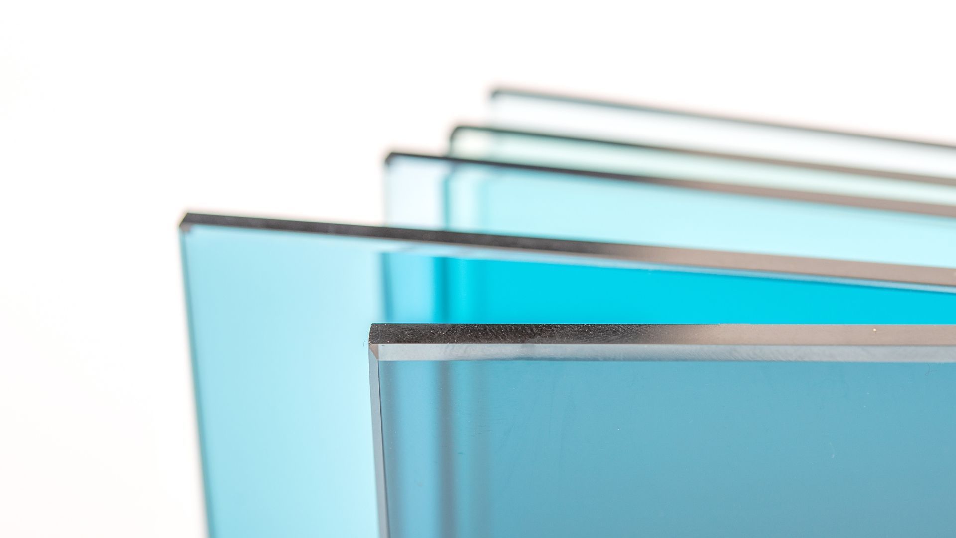 Stack of light-blue glass panes, edges visible, against a white background.