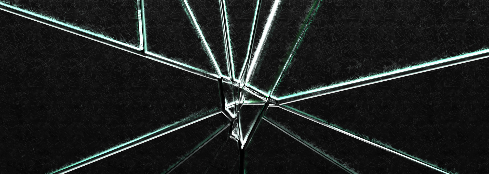 Cracked glass with light-colored, angular fractures against a dark background.