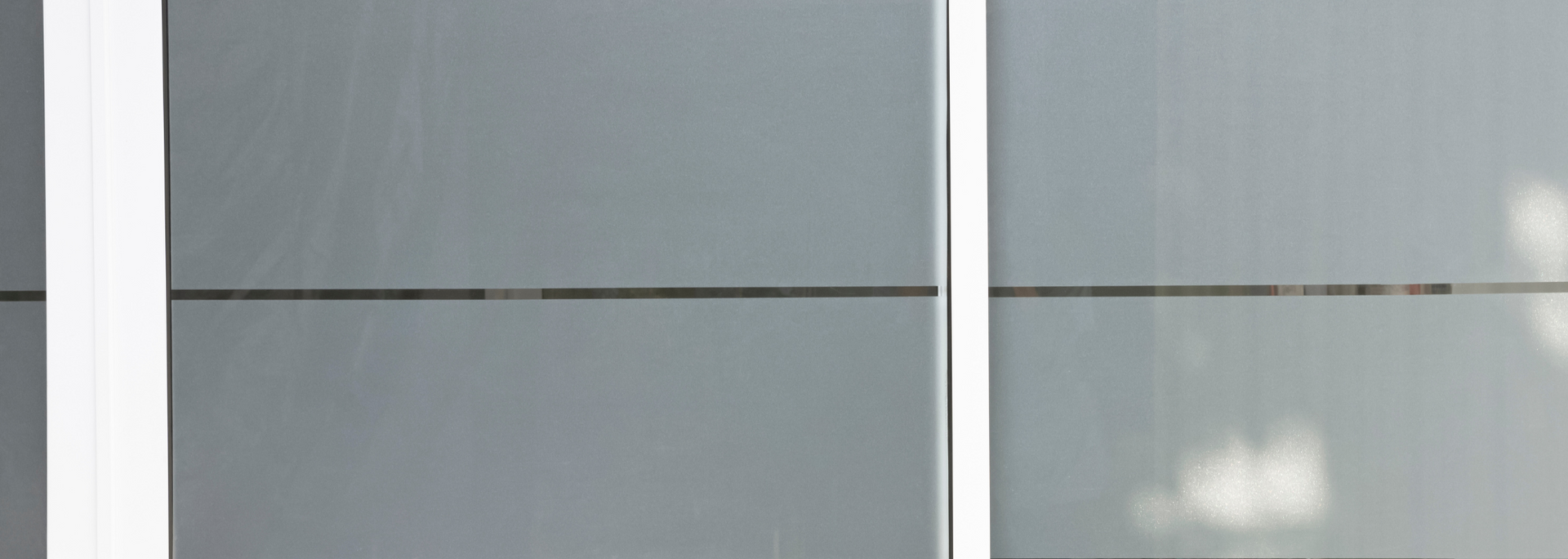 Gray wall panels with a white vertical beam on the left and a thin dark line.