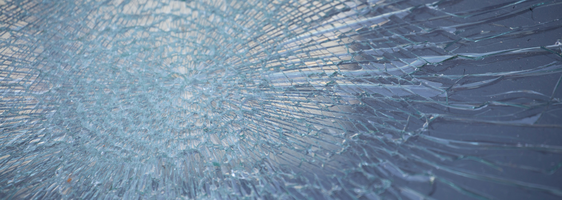 Shattered glass with a pattern of cracks radiating outward.