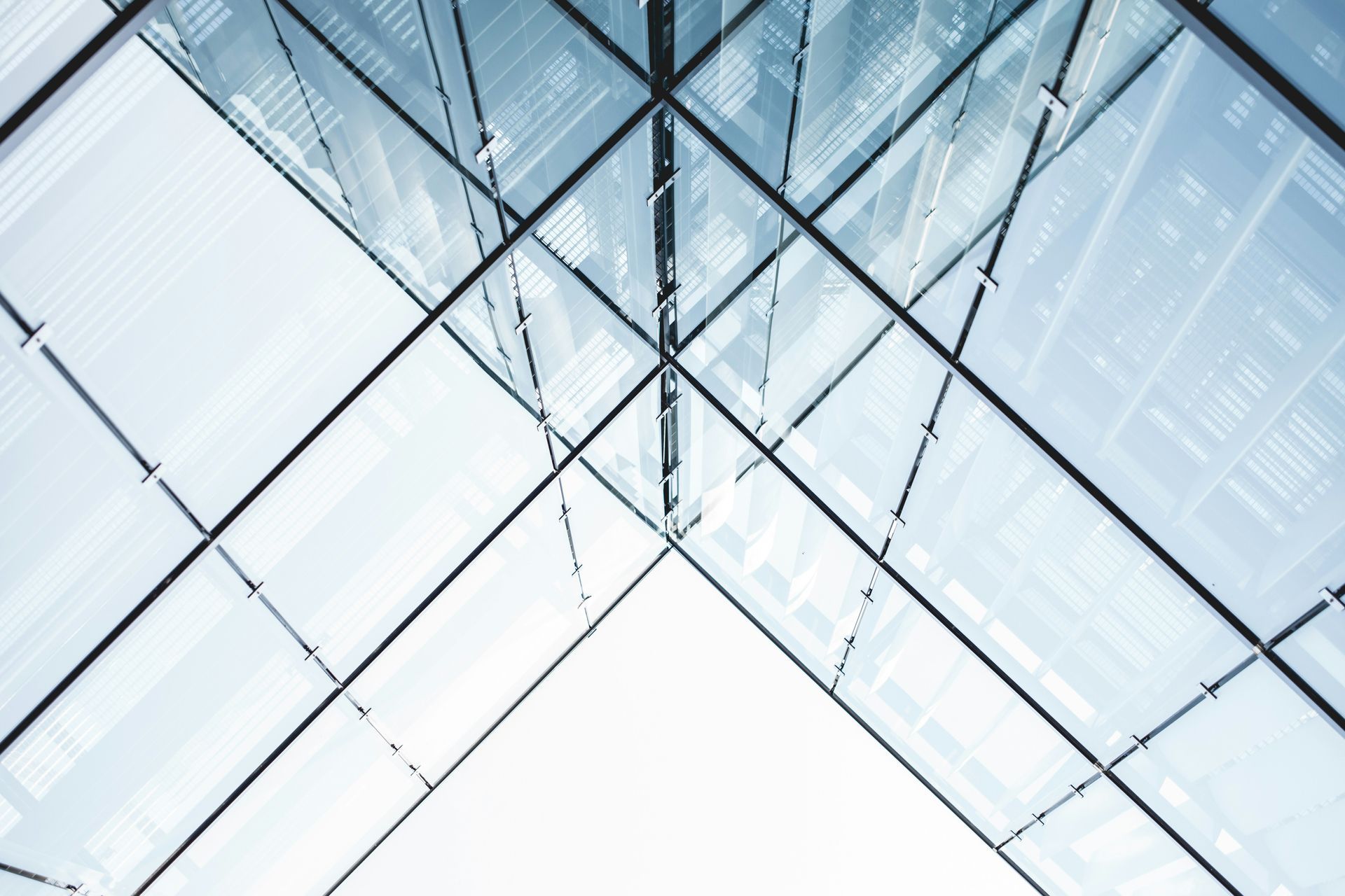 Abstract view up into glass and metal skyscraper structure, geometric design.