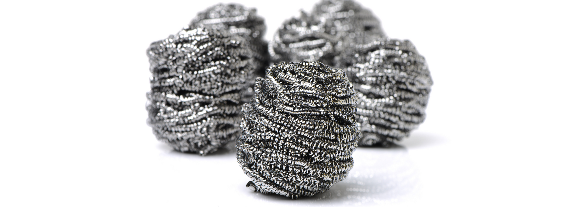 Metal scouring pads on a white surface.