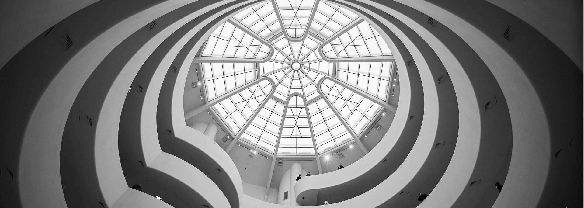 Interior view of the Guggenheim Museum, looking up at the central glass dome and spiraling ramp.