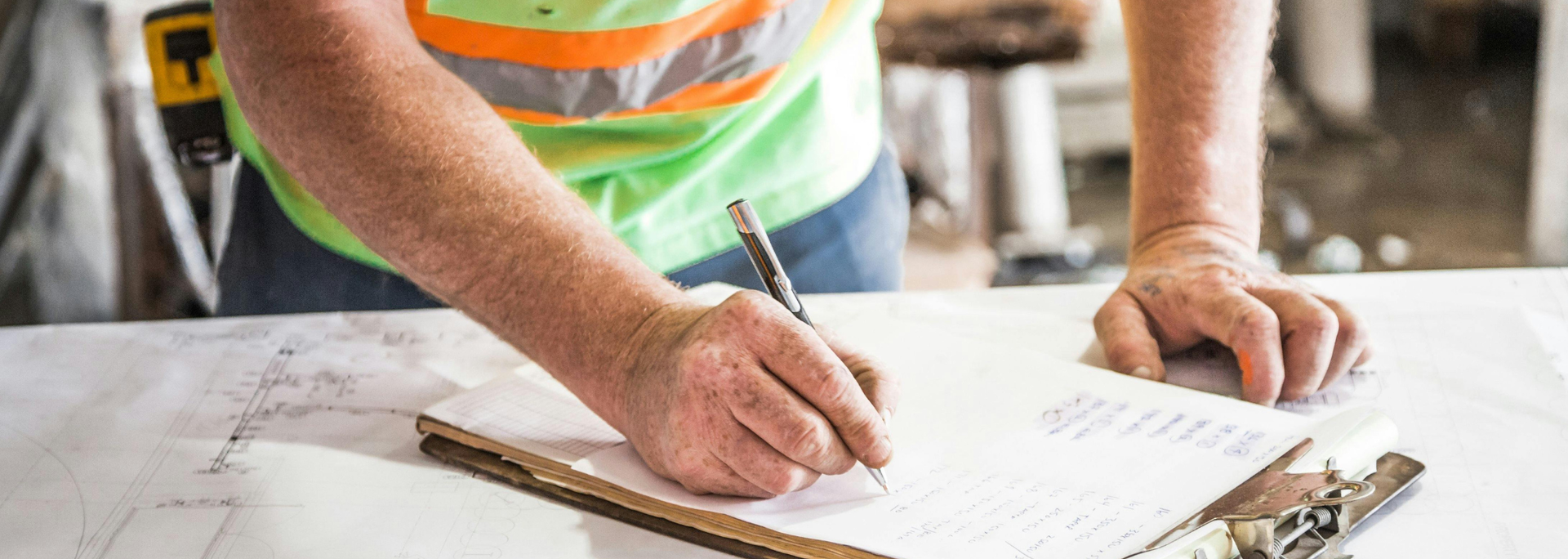 Picture of someone writing at a construction site. 