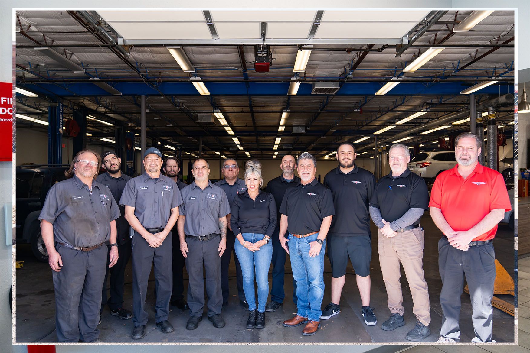 A group of people are posing for a picture in a garage. | Zia Automotive