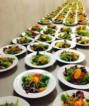 A long table topped with plates of salads.
