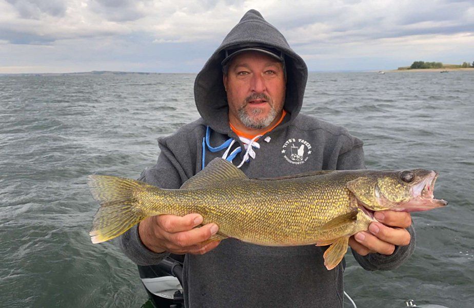 man holding fish on a cloudy day