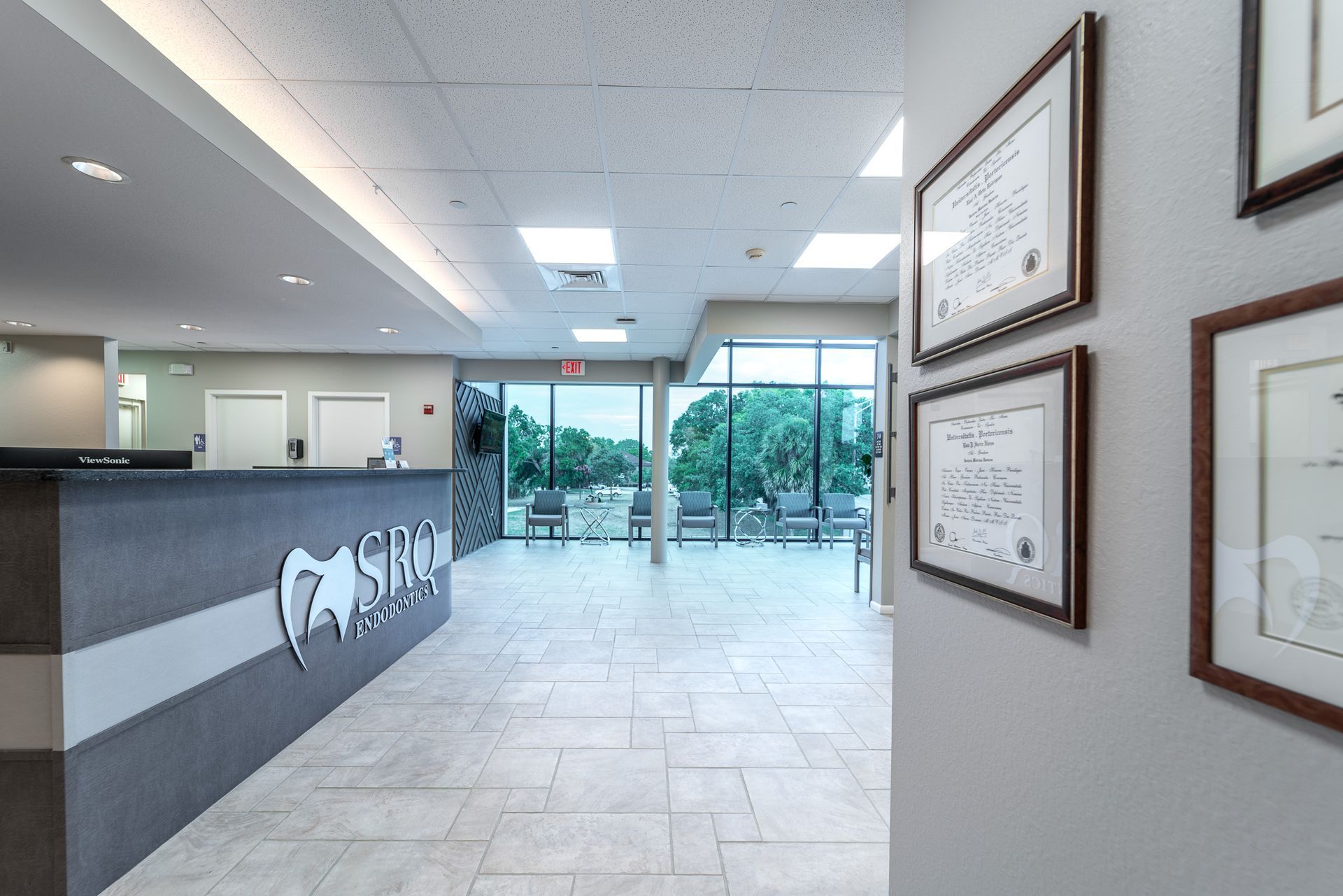 A dental office with a reception desk and a row of framed pictures on the wall.