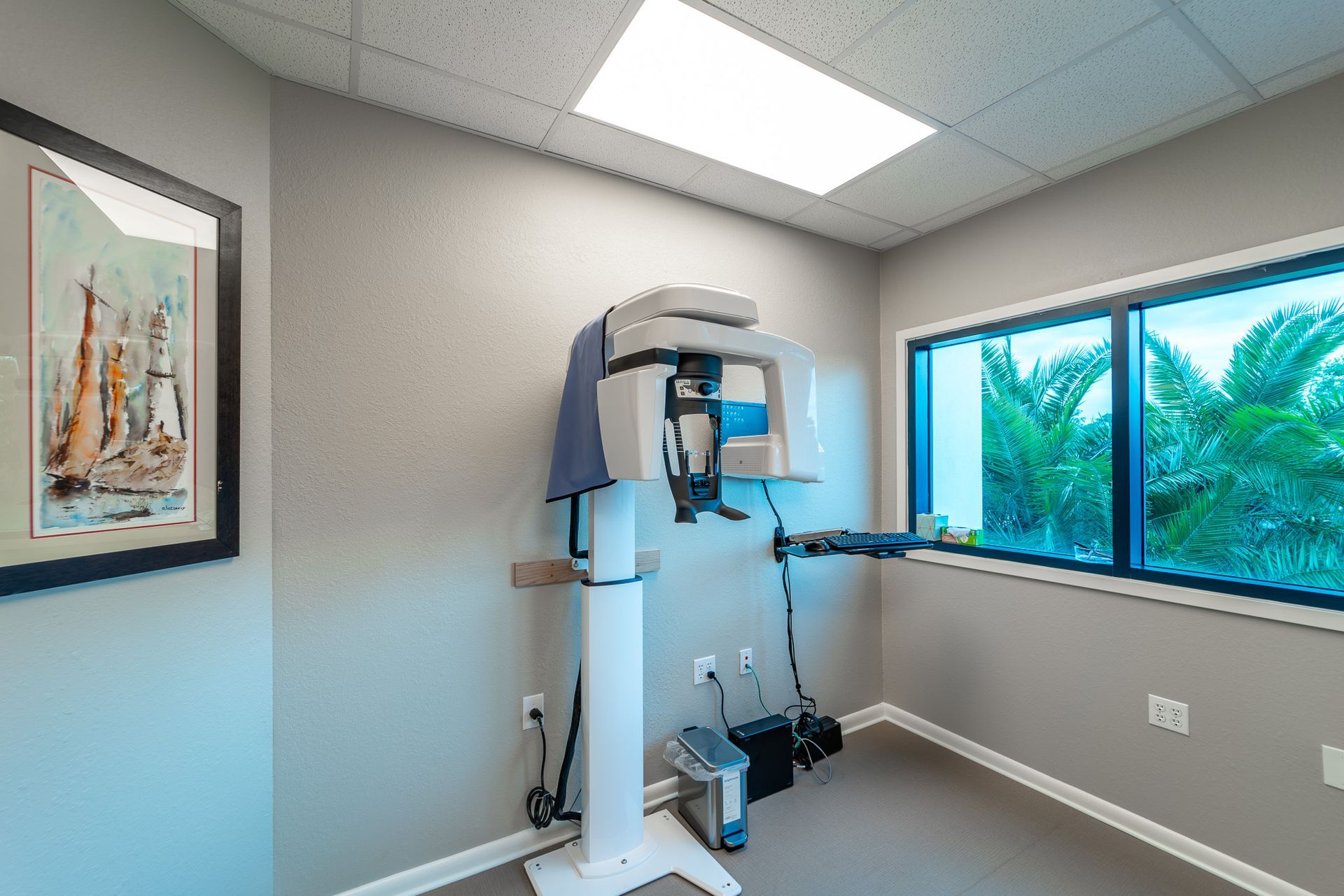 A room with a x-ray machine and a picture on the wall.