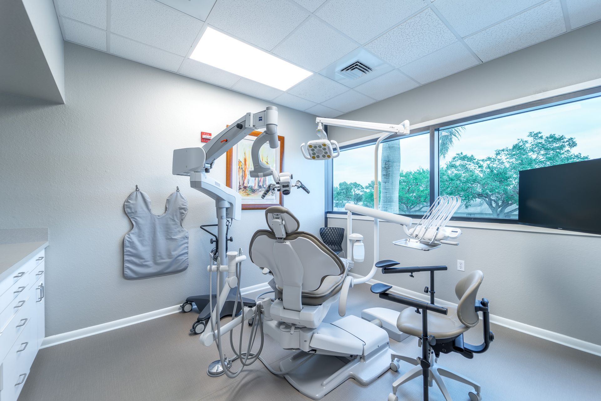 A dental office with a dental chair and a microscope.