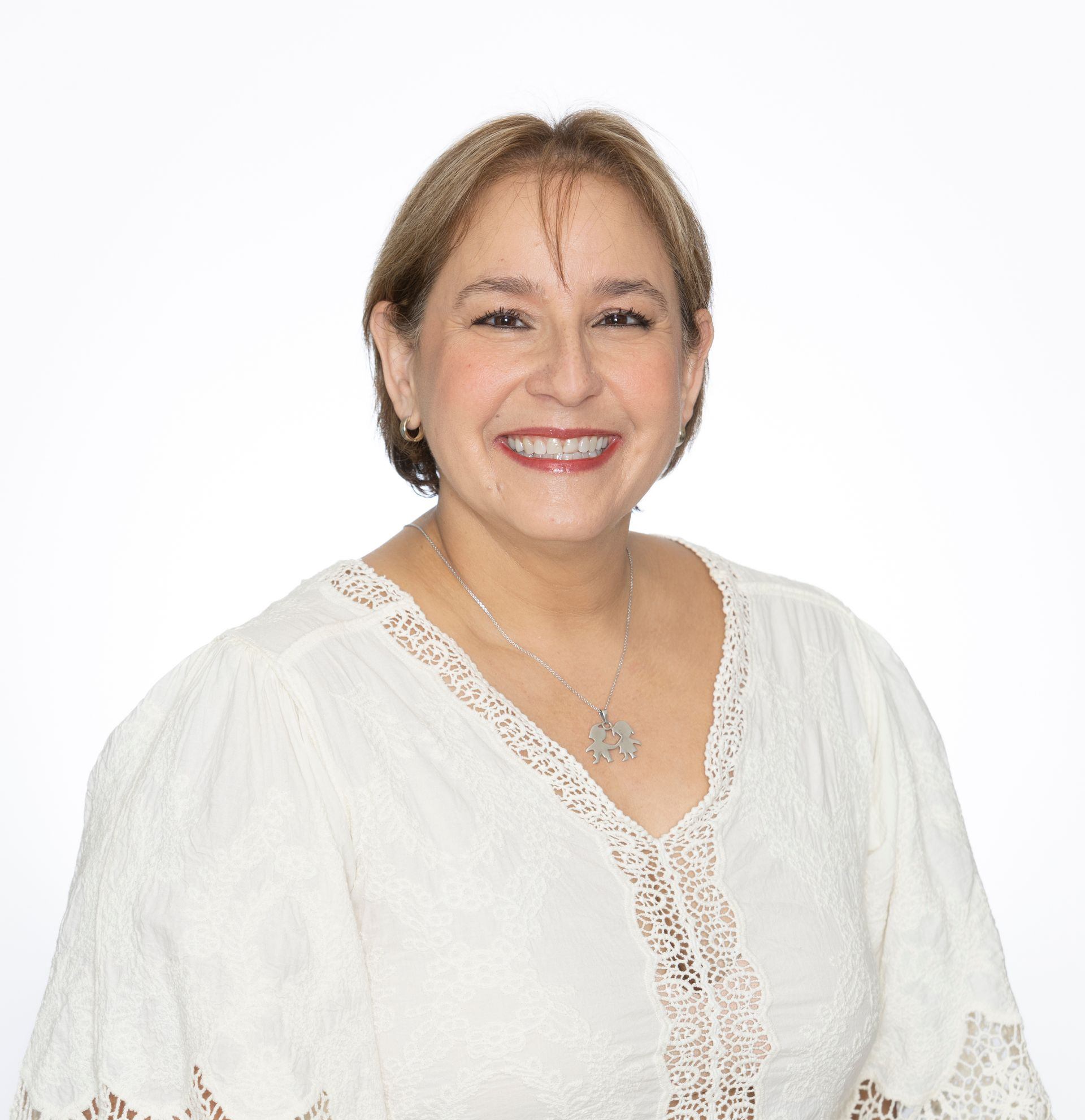 A woman wearing a striped shirt and a necklace smiles for the camera.
