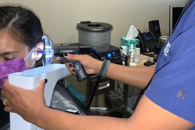 Person checking a blocked ear after wax removal at home.