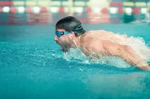 Swimmer wearing custom-fit swimming earplugs in the pool
