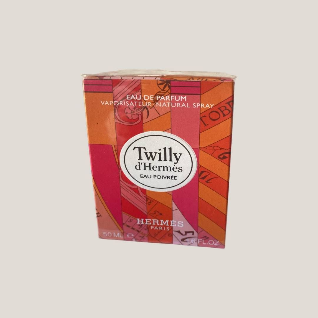 Caja de perfume Hermès Twilly d'Hermès con estampado geométrico en naranja, rojo y rosa.