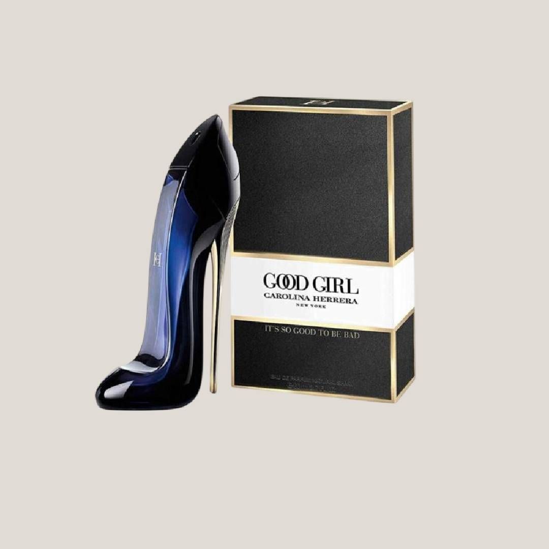 Frasco de perfume negro con forma de tacón alto junto a una caja de perfume Good Girl negra y dorada.
