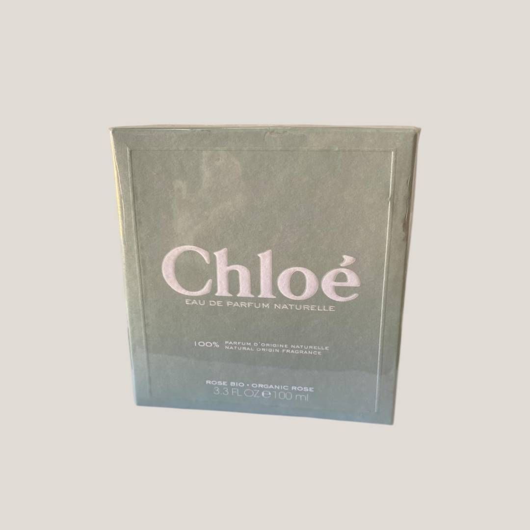 Caja de perfume Chloé en envase verde y azul apagado sobre un fondo liso