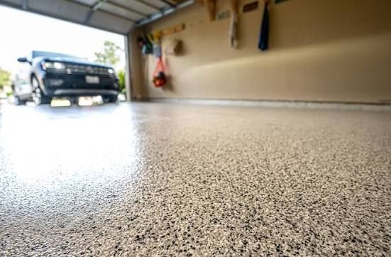 Speckled polyaspartic garage floor coating inside a clean, organized two-car garage