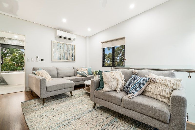 A living room with two couches and a rug.