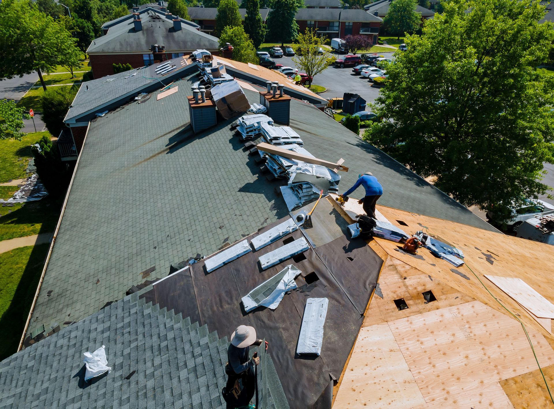 Roofers replacing shingles on a large residential roof. Roofers replacing shingles on a large residential roof.