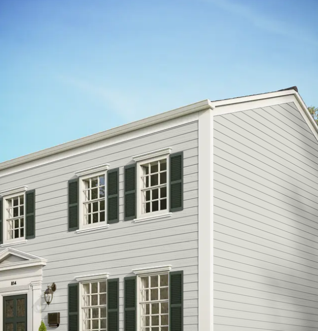 White two-story house exterior with green shutters and a light blue sky