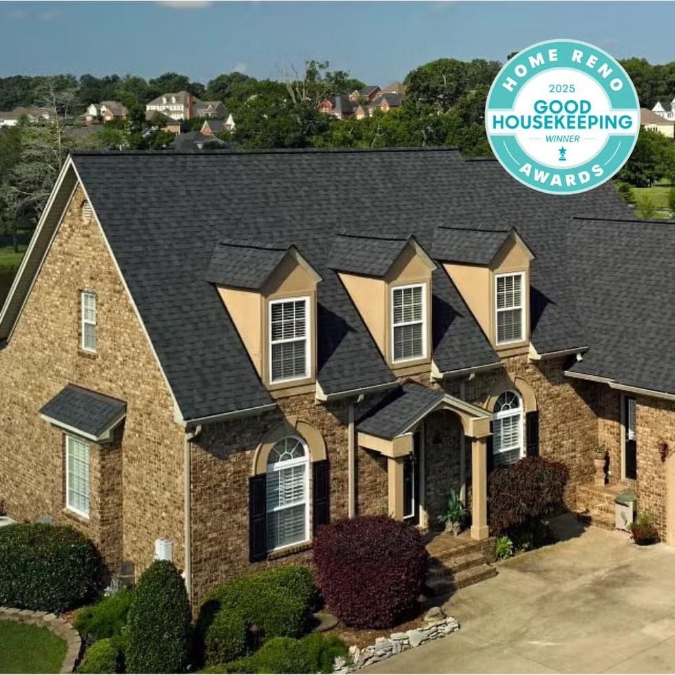 Brick house with dark roof and dormers;