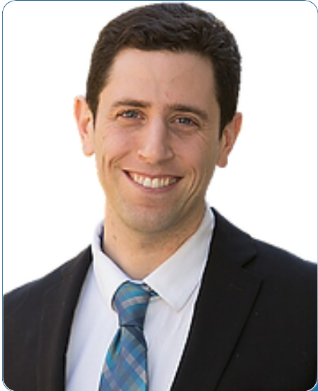 A man in a suit and tie is smiling for the camera
