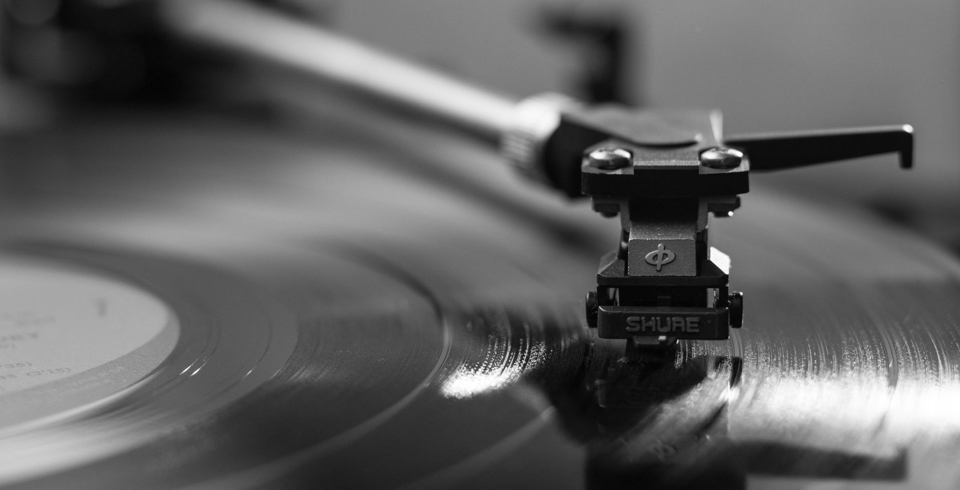Close-up of a vinyl record spinning on a turntable, with the tonearm and stylus in focus.