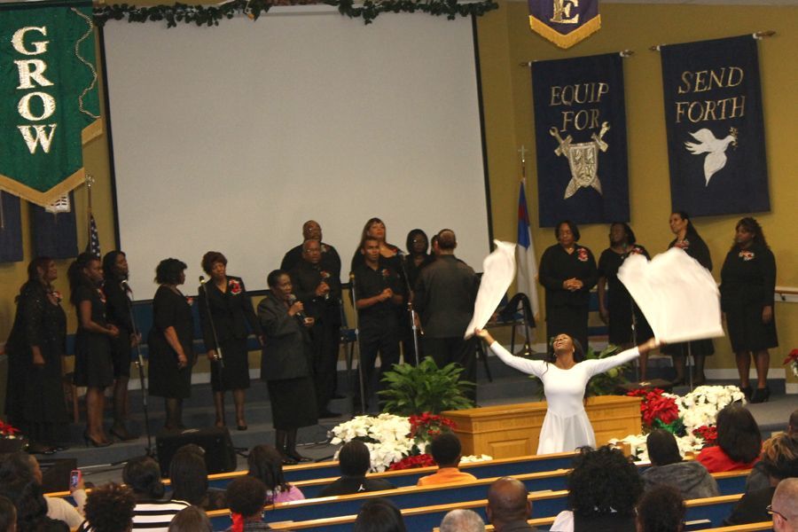 Church choir on stage with white flags and banners reading “Grow,” “Equip,” and “Send Forth”