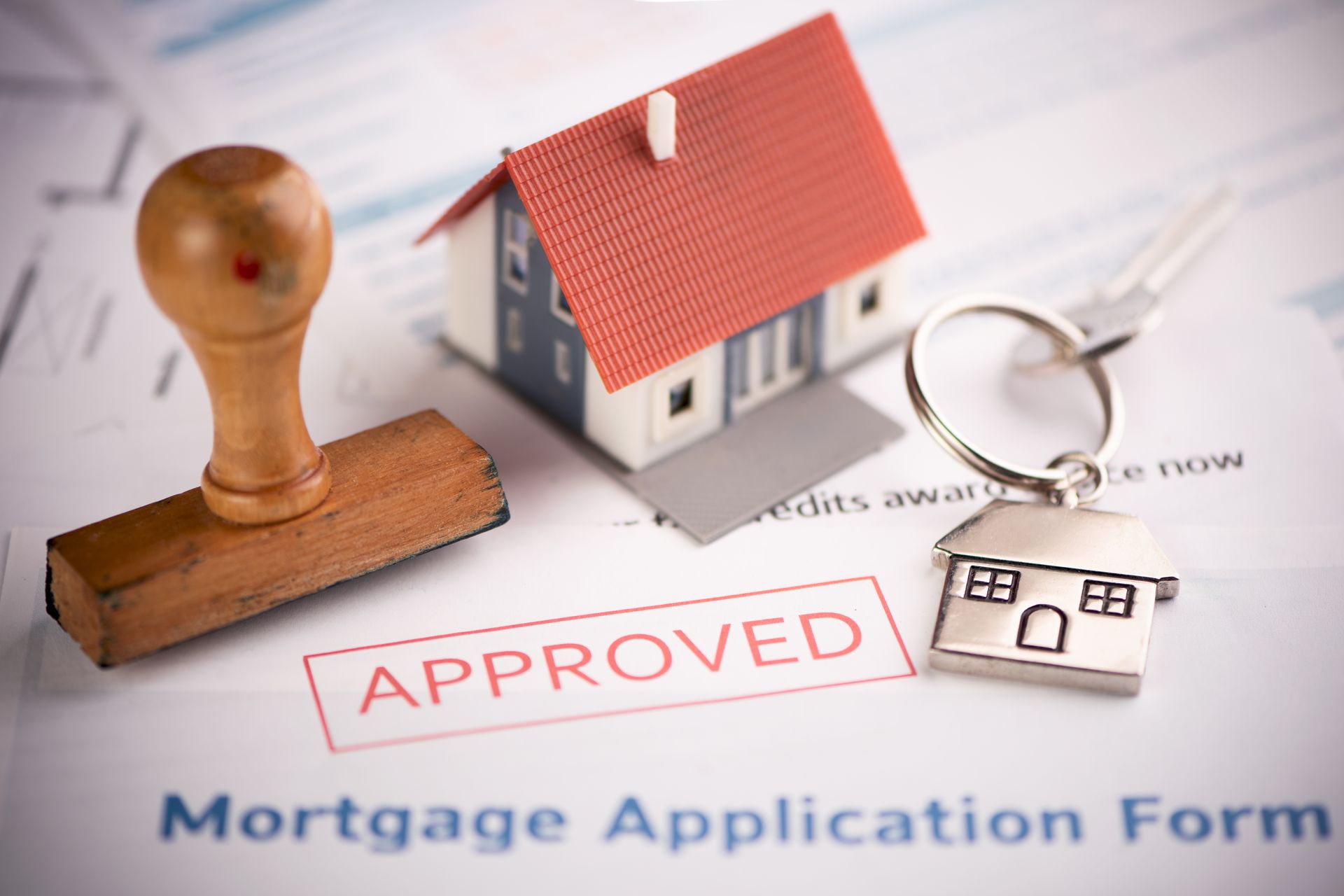 An approved Mortgage loan application form with house key and rubber stamp