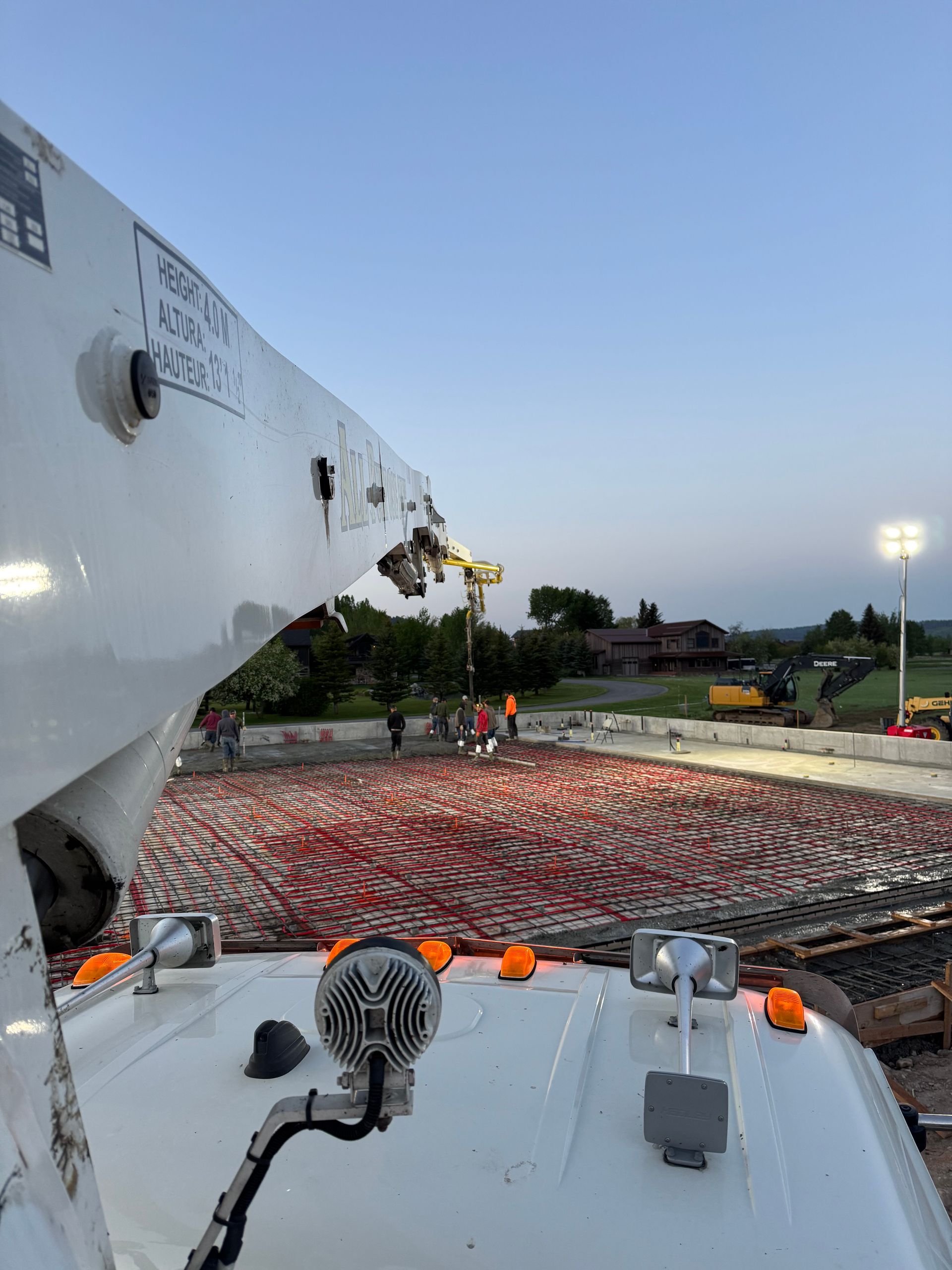 An aerial view of a construction site with a crane pumping concrete