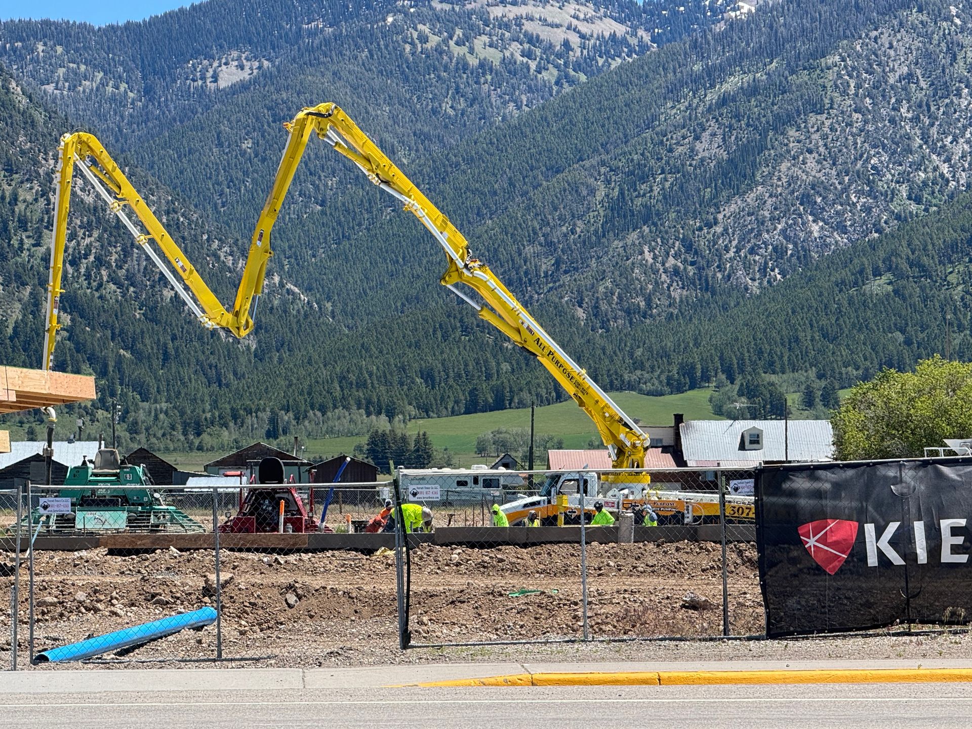 A concrete floor is being poured into a warehouse.