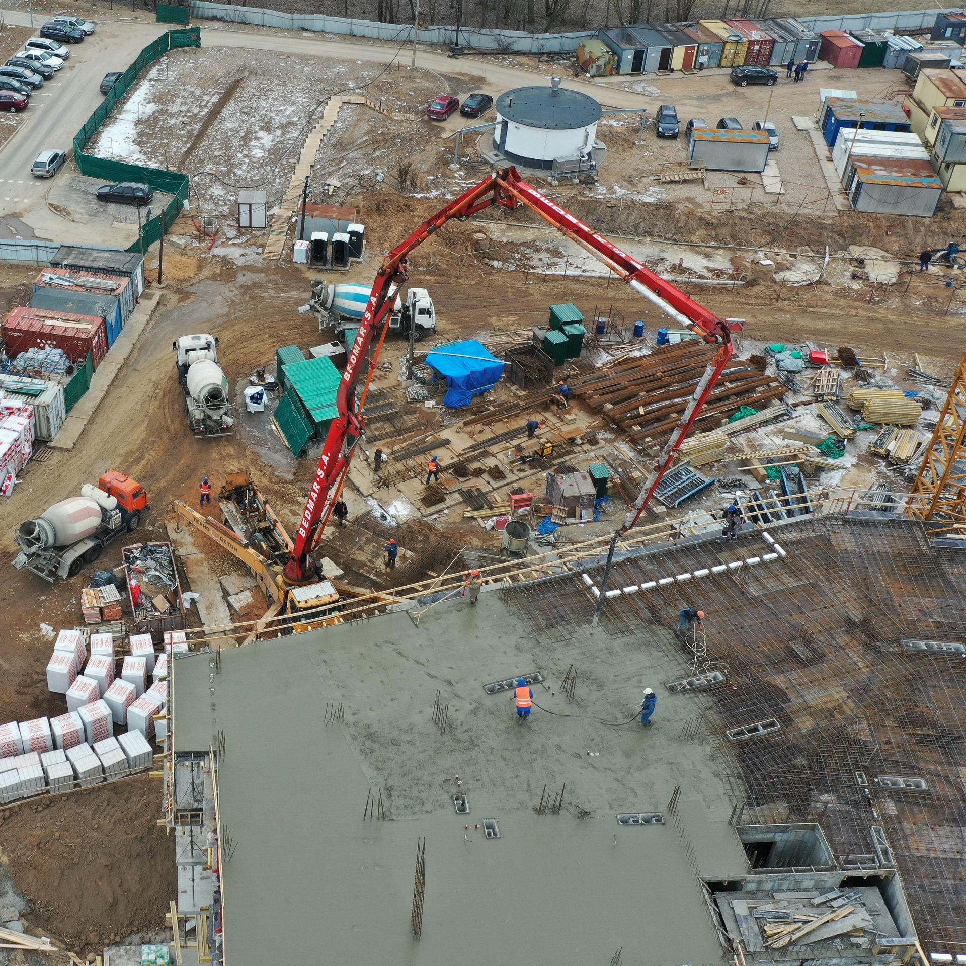 An aerial view of a construction site with a crane pumping concrete