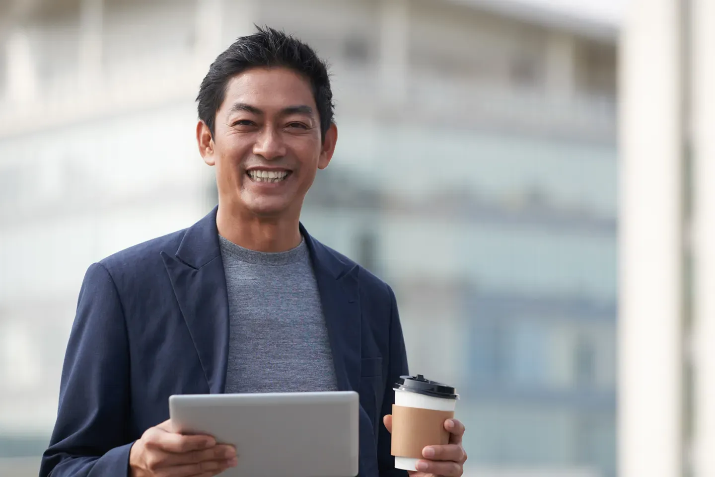 Asian businessman holding coffee in need of executive coaching