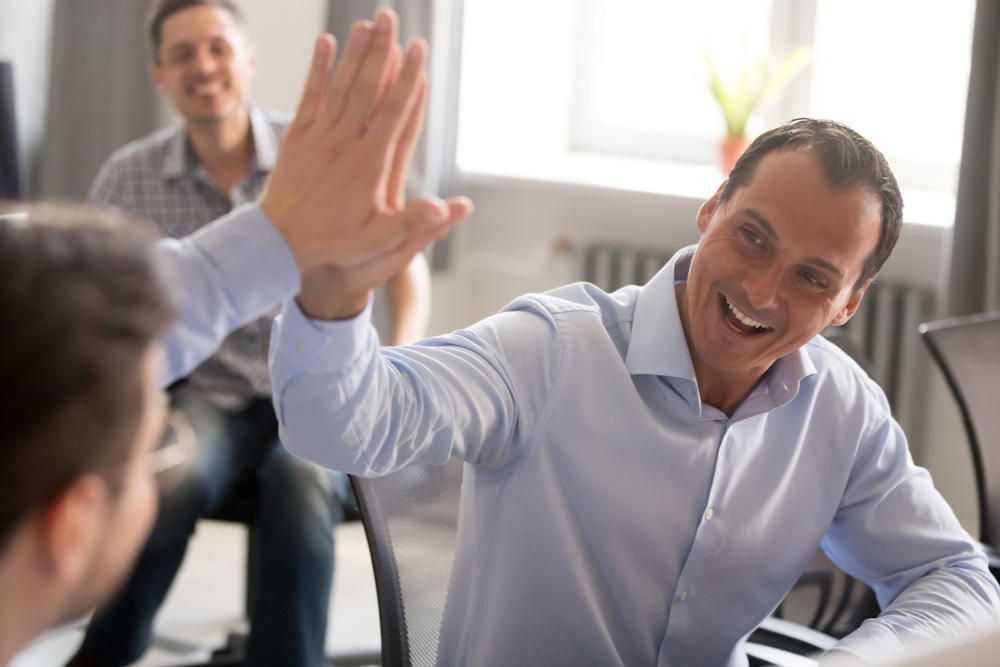 two executives giving a high-five to each other after one gave a referral in their job search