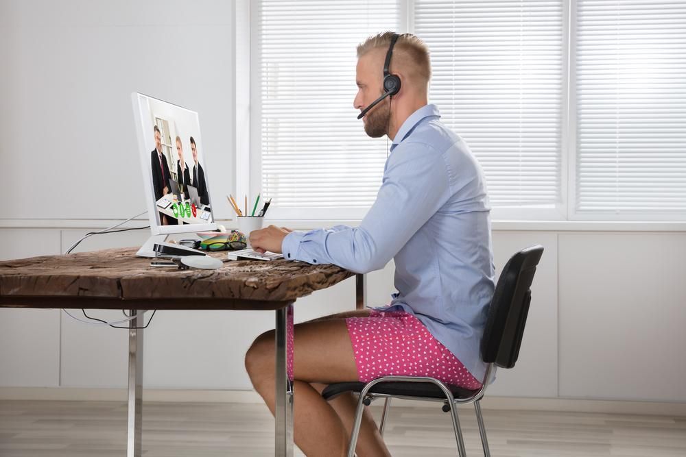 Professional preparing for a video interview while wearing a dress shirt and tie with only boxers